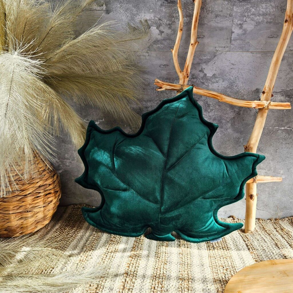 Zielona poduszka dekoracyjna liść klonu z weluru w przytulnym salonie