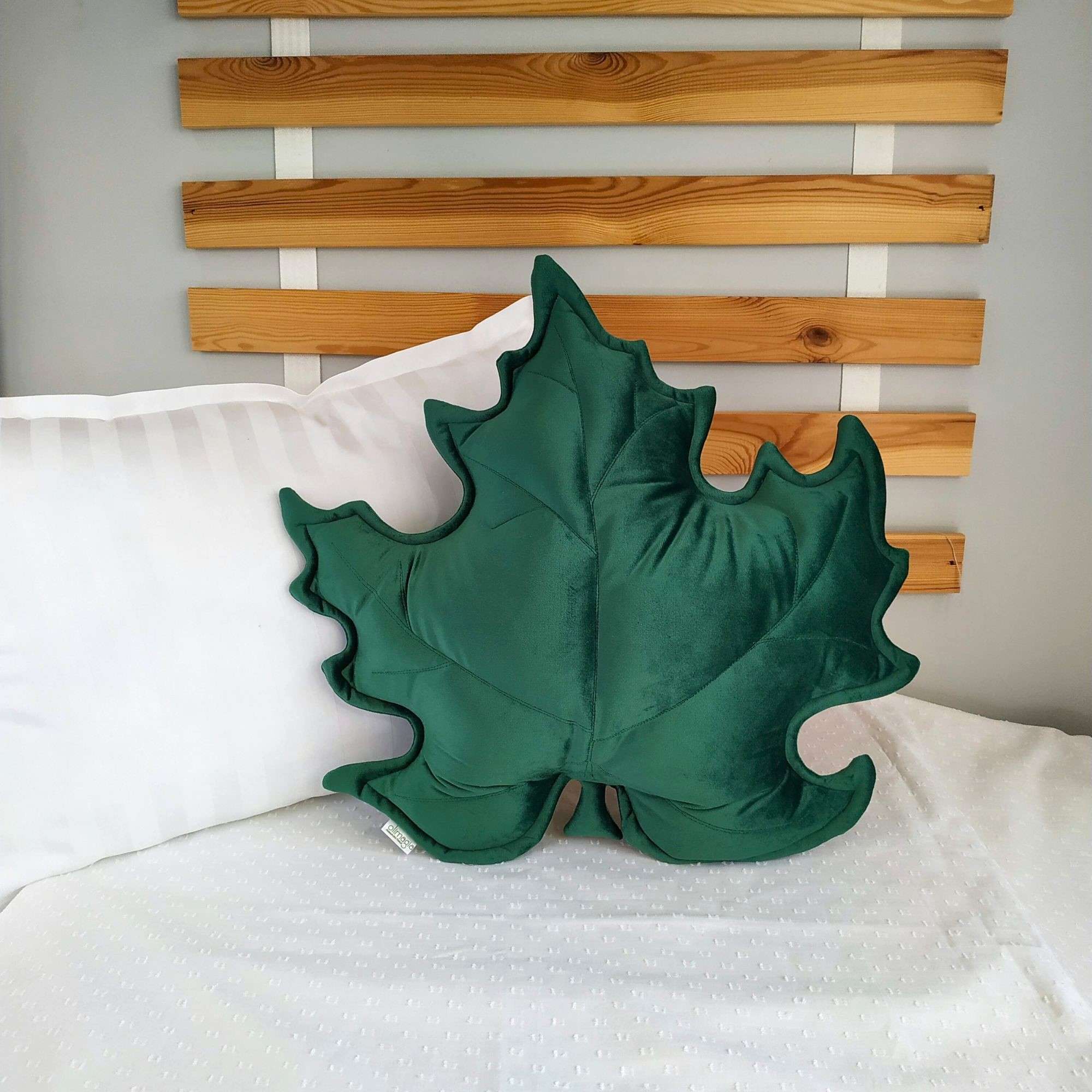 Zielona poduszka dekoracyjna liść klonu z weluru w przytulnym salonie