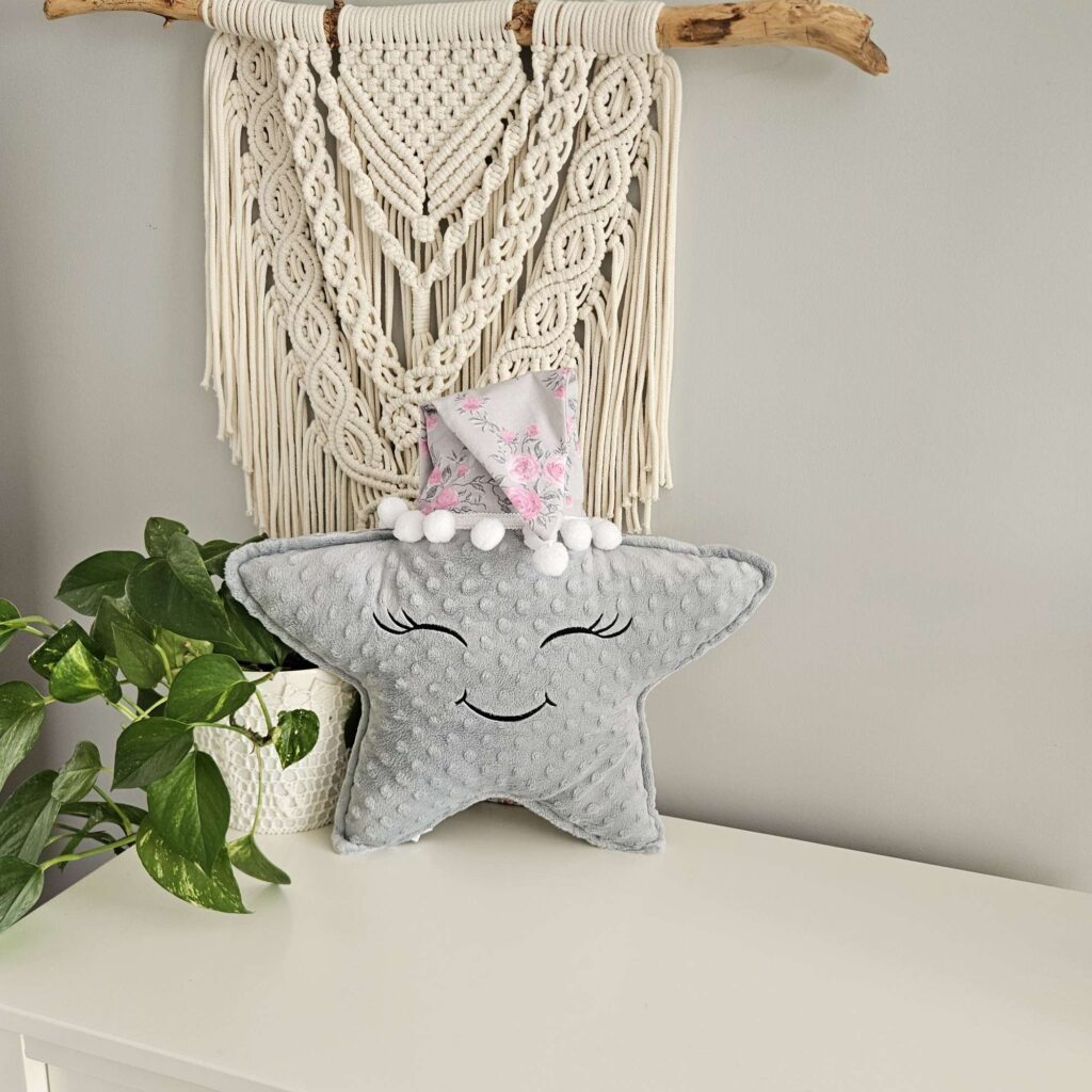 Szara poduszka gwiazdka z uśmiechniętą buzią