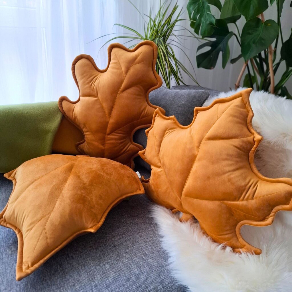 Zestaw 3 musztardowych poduszek dekoracyjnych w kształcie liści, idealny jako prezent na parapetówkę.