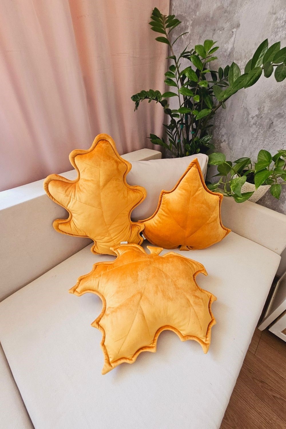 Zestaw 3 musztardowych poduszek dekoracyjnych w kształcie liści, idealny jako prezent na parapetówkę.