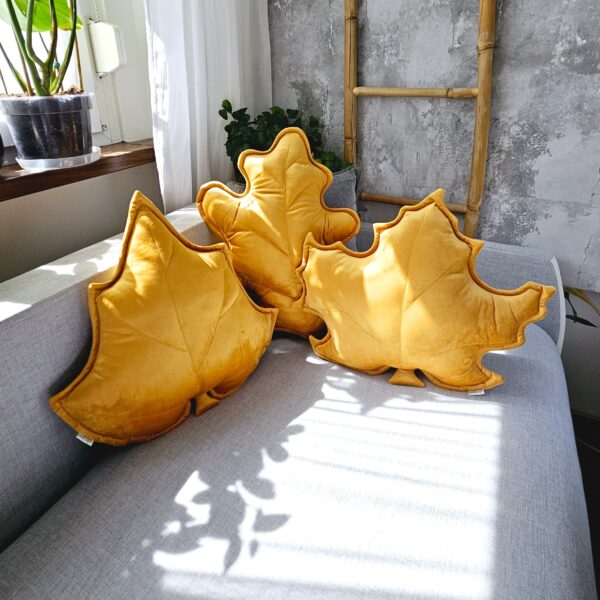 Zestaw 3 musztardowych poduszek dekoracyjnych w kształcie liści, idealny jako prezent na parapetówkę.