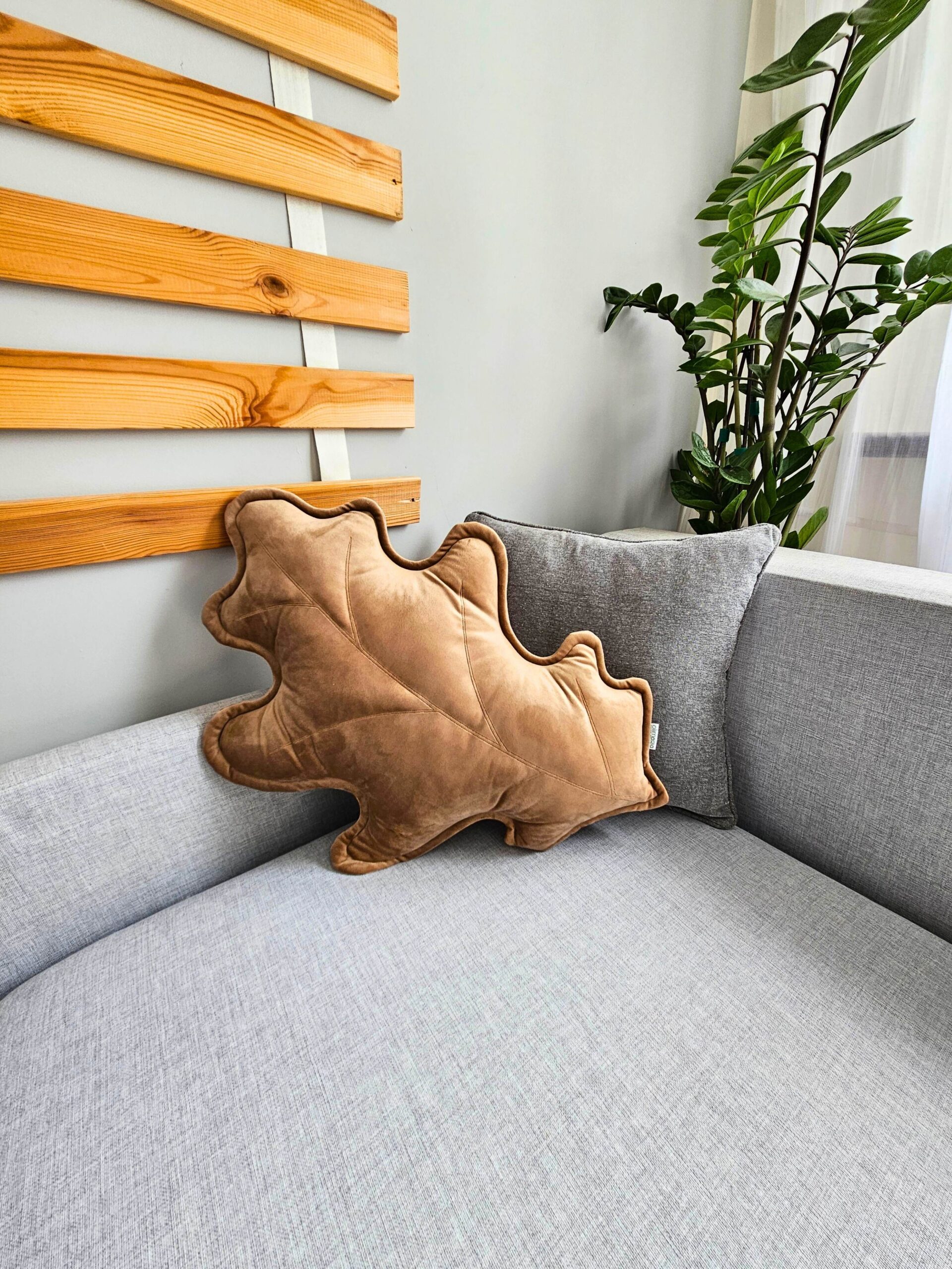 Beżowa poduszka dekoracyjna liść dębu w eleganckim salonie