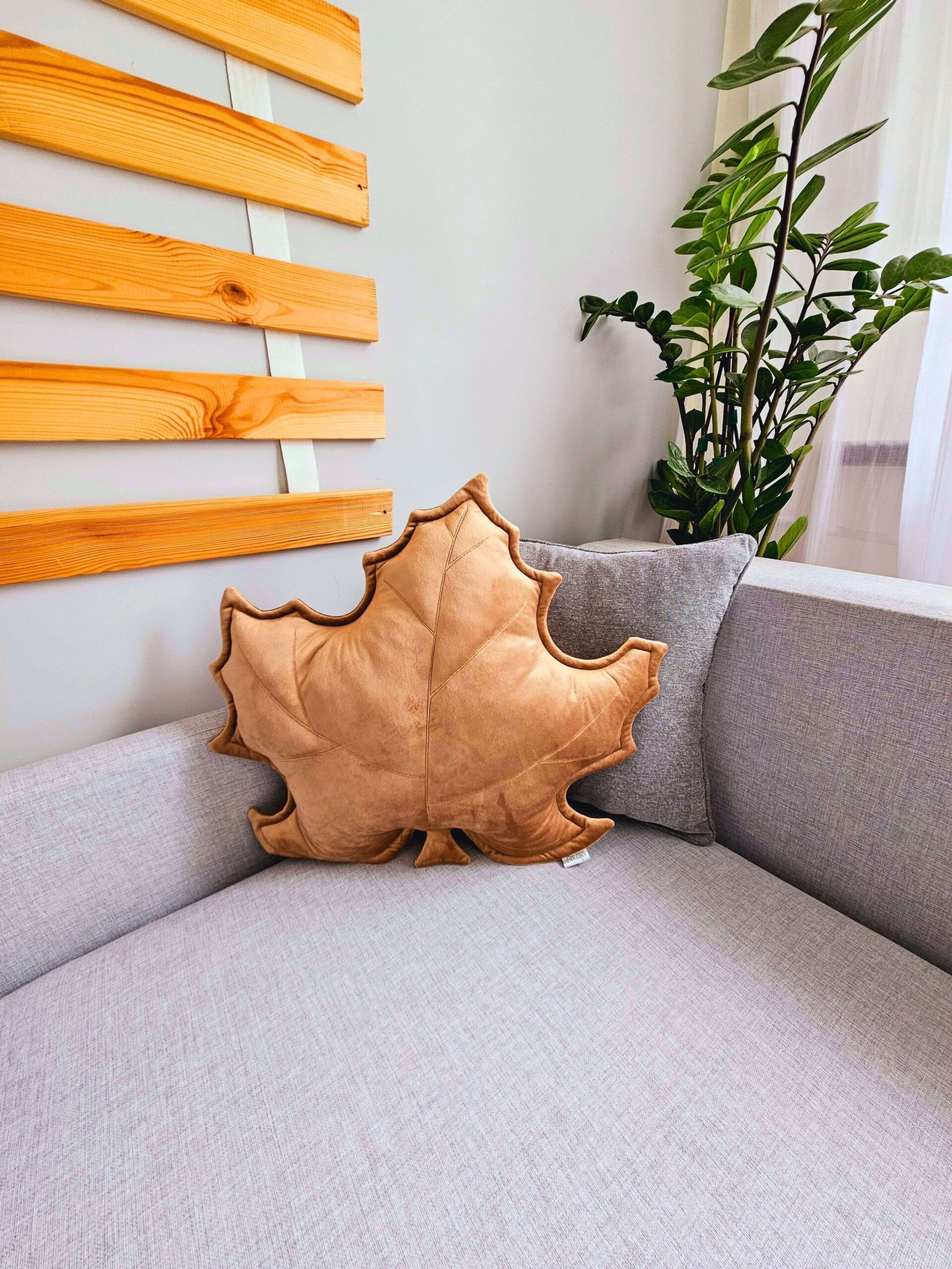 Beżowa poduszka dekoracyjna liść klonu w przytulnym salonie